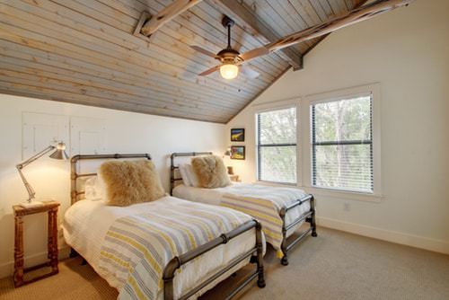 A shared room at Luna Rio with two twin iron beds beneath a vaulted ceiling.