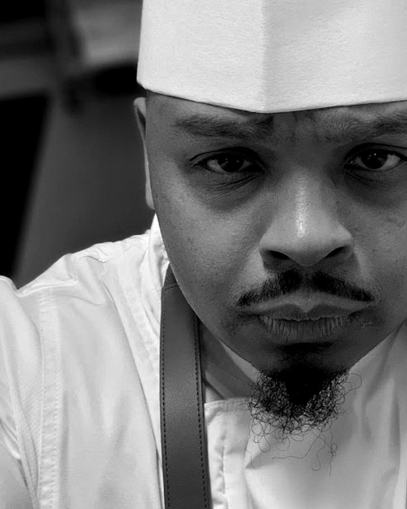 De'Anthony Colbert in his chef's whites and toque, in black and white.